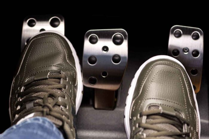 Motorista pressionando o pedal da embreagem do carro