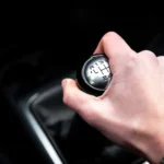 Mão do motorista segurando a marcha de carro durante a troca de velocidades no interior do veiculo