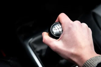 Mão do motorista segurando a marcha de carro durante a troca de velocidades no interior do veiculo